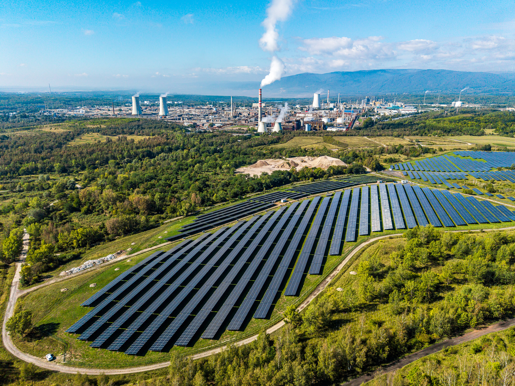 Fotovoltaická elektrárna ČEZ v Růžodole a v pozadí areál ORLEN Unipetrol v Záluží u Mostu