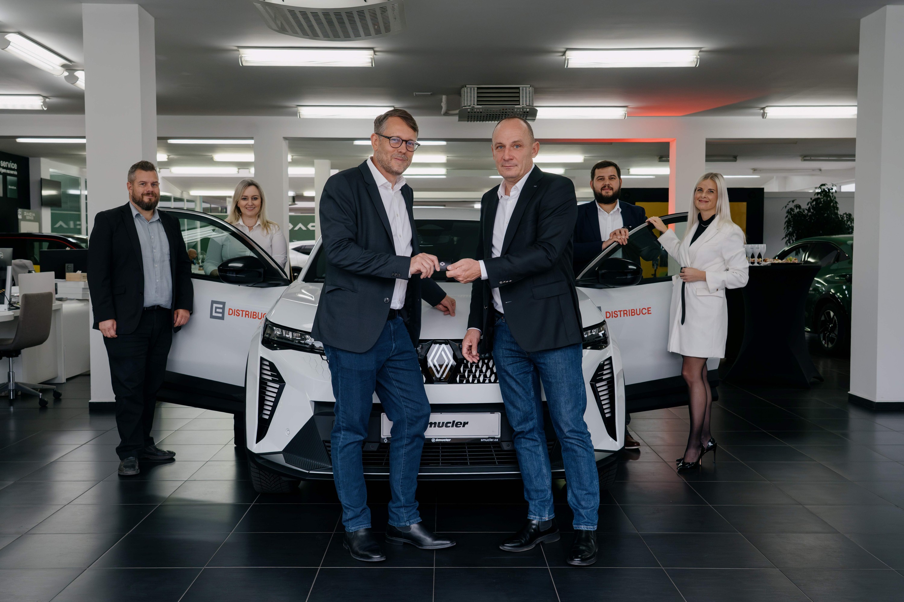 Manažer útvaru dopravní služby ČEZ Jakub Bosák (v popředí vlevo) při převzetí elektromobilů v Klatovech