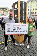 Lenka Vonka Černá, ředitelka Dobrovolnického centra, z.s., Ústí nad Labem, se symbolickým šekem na 50 390 korun. Vlevo Radek Jirgl, neúnavný moderátor Oranžových kol Nadace ČEZ. Oba s palcem nahoru jako projevem díků všem šlapajícím.  