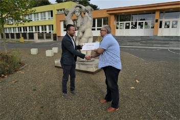 Martin Novák, manažer prodeje ČEZ Teplárenské, předává symbolický šek na 20 000 korun řediteli kadaňské ZŠ Na Podlesí Zdeňku Hosmanovi (vpravo). Škola za tento finanční dar pořídila robotické stavebnice pro výuku ICT. 

