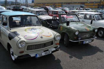 Kübelwagen pro východoněmeckou pohraniční stráž v kontrastu s veselým Trabantem s variací Slunce, seno... na kapotě