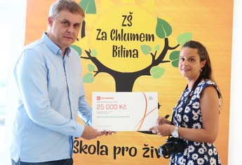 Symbolický šek ve výši 25 000 korun převzala z rukou Milana Bláhy, zástupce ČEZ Teplárenské,  ředitelka ZŠ  Za Chlumem v Bílině  Barbora Schneiderová. Jak dokazuje fotoaparát,  škola si již za celou částku pořídila pomůcky pro výuku Digitální technologie a Informatiky.