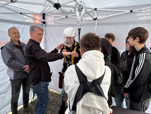 Náborový specialista Skupiny ČEZ Martin Klacián se rovněž zapojil do praktických ukázek a seznamoval návštěvníky stanu ČEZ Distribuce s jištěním během prací ve výškách a ochrannými pomůckami během práce pod napětím. Vlevo přihlíží Stanislav Hejhal, vedoucí oddělení Sítě Příbram.
  