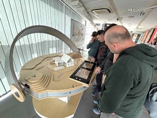 Radní z vinařské obce Kobylí, uprostřed starosta Pavel Kotík, nad simulátorem FVE v Infocentru Elektrárny Ledvice.